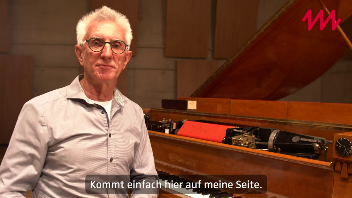 Mitarbeiter sitzt am Flügel